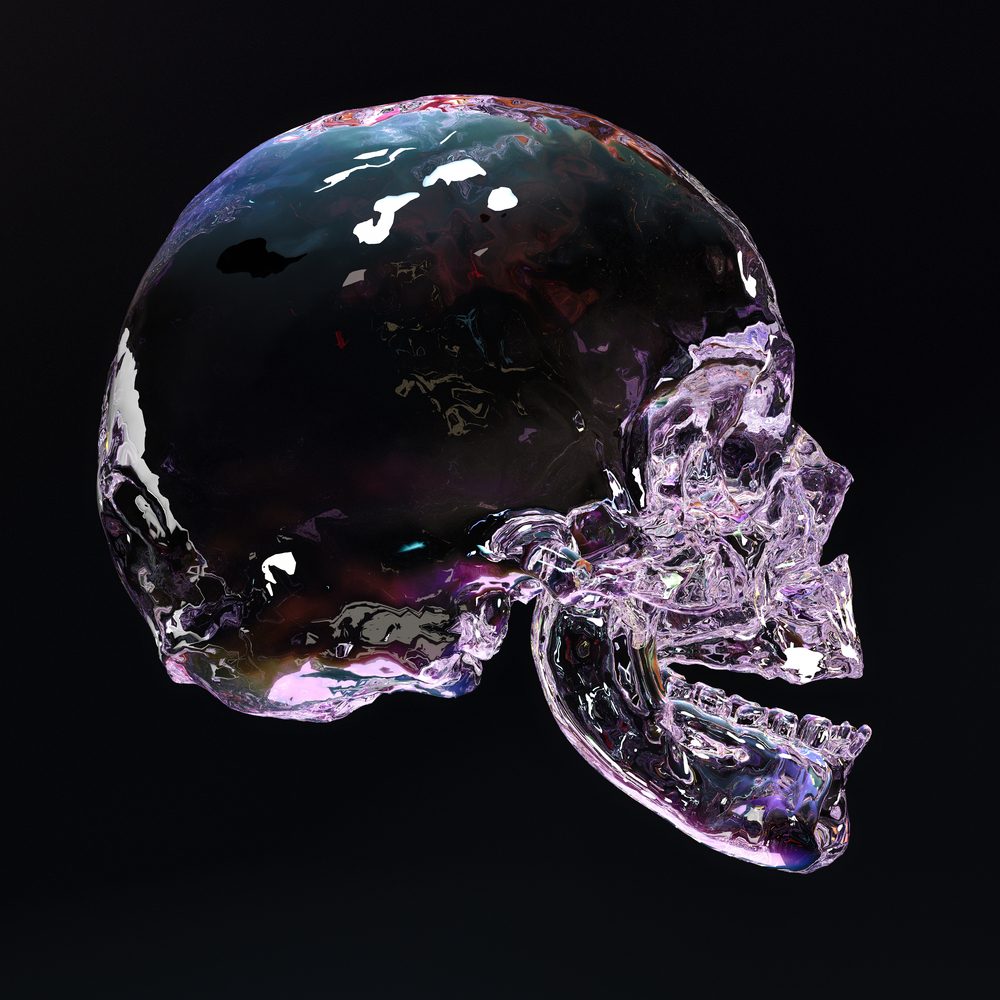 A delicate crystal skull illuminated in seven colors on a dark background. 3d illustration.